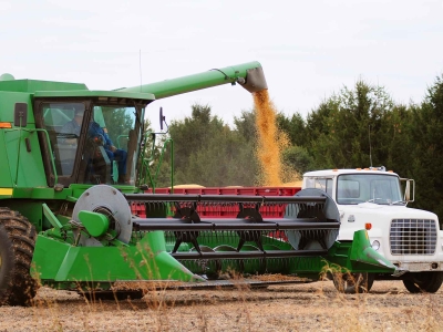 A combine fills a hauler with grain