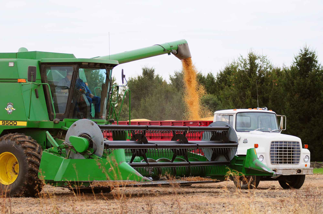 A combine fills a hauler with grain